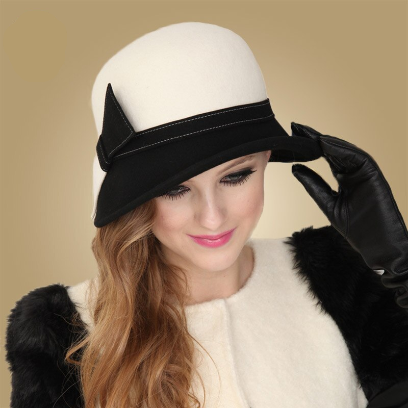 Femme tenant le chapeau qu'elle porte sur la tête d'une main avec un gant noir, le châpeau est élégant, noir et blanc avec un nœud sur le côté