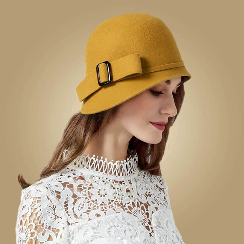 Femme de profil portant un élégant chapeau cloche vintage jaune moutarde , avec un haut blanc en dentelles