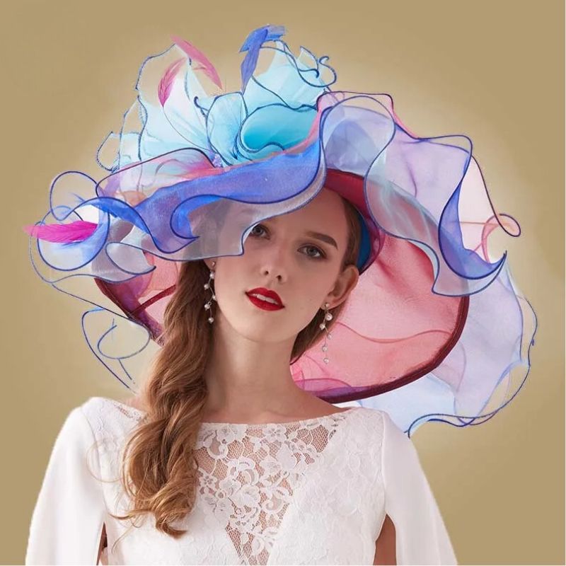 Chapeau Catherinette au Design Fleuri pour Grandes Occasions bleu porté par une femme qui porte des boucles d'oreille
